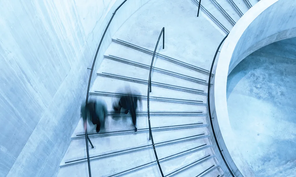Birdseye view of people walking down spiral stairs