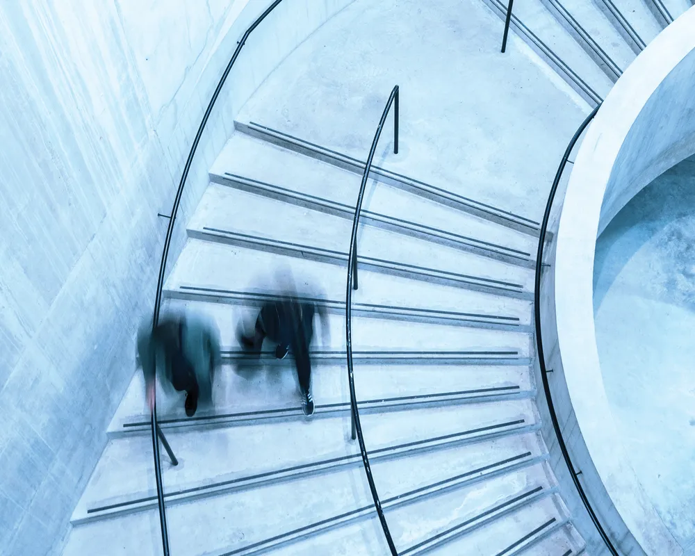 Birdseye view of people walking down spiral stairs