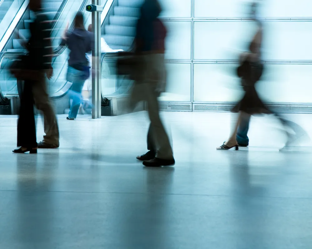 Business people walking. Office escalators in the background